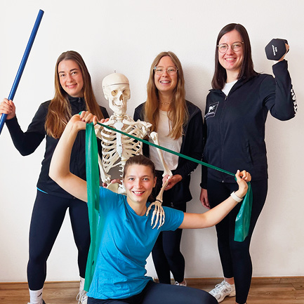Sympathisches Physio-Team zeigt Trainingsfreude mit Skelett und Geräten – wir suchen Verstärkung im Bereich Physiotherapie